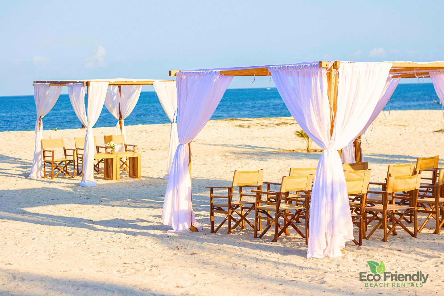 White beach cabanas and wooden chairs arranged for a Diani celebration