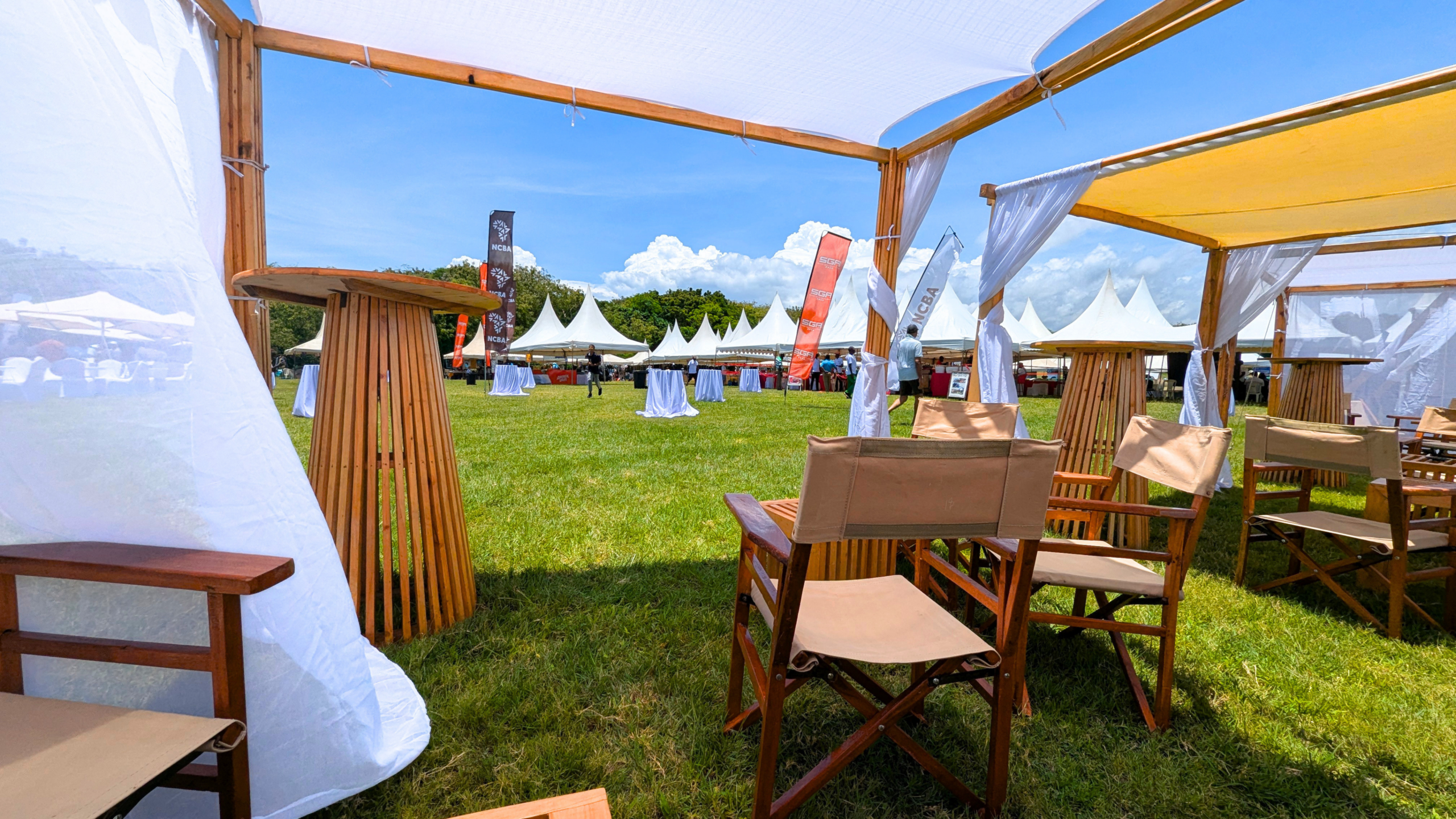 Reusable wooden event furniture beneath white canopies at the Diani Charity Goat Derby 2026