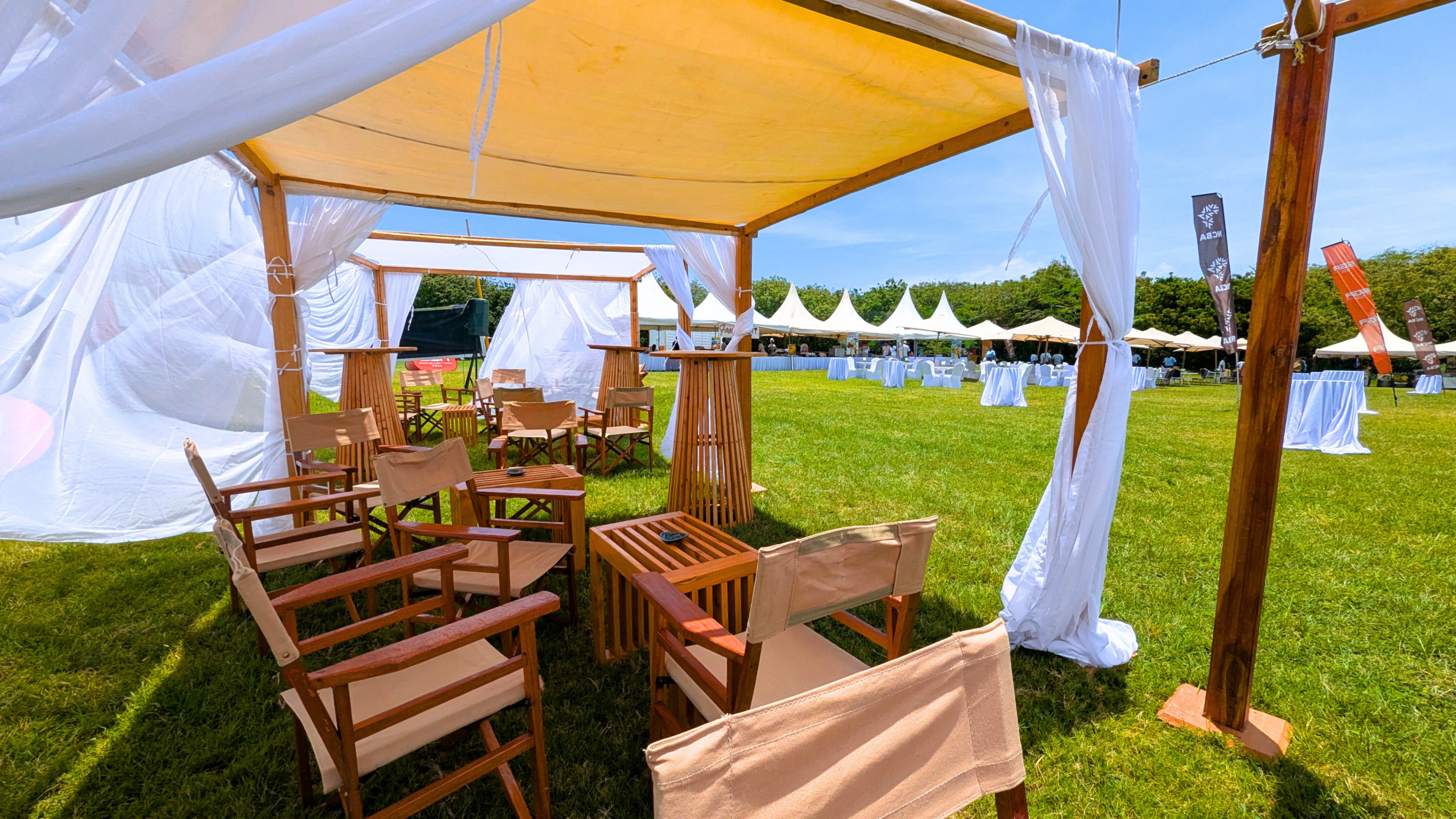 Locally made wooden event furniture displayed inside a white canopy