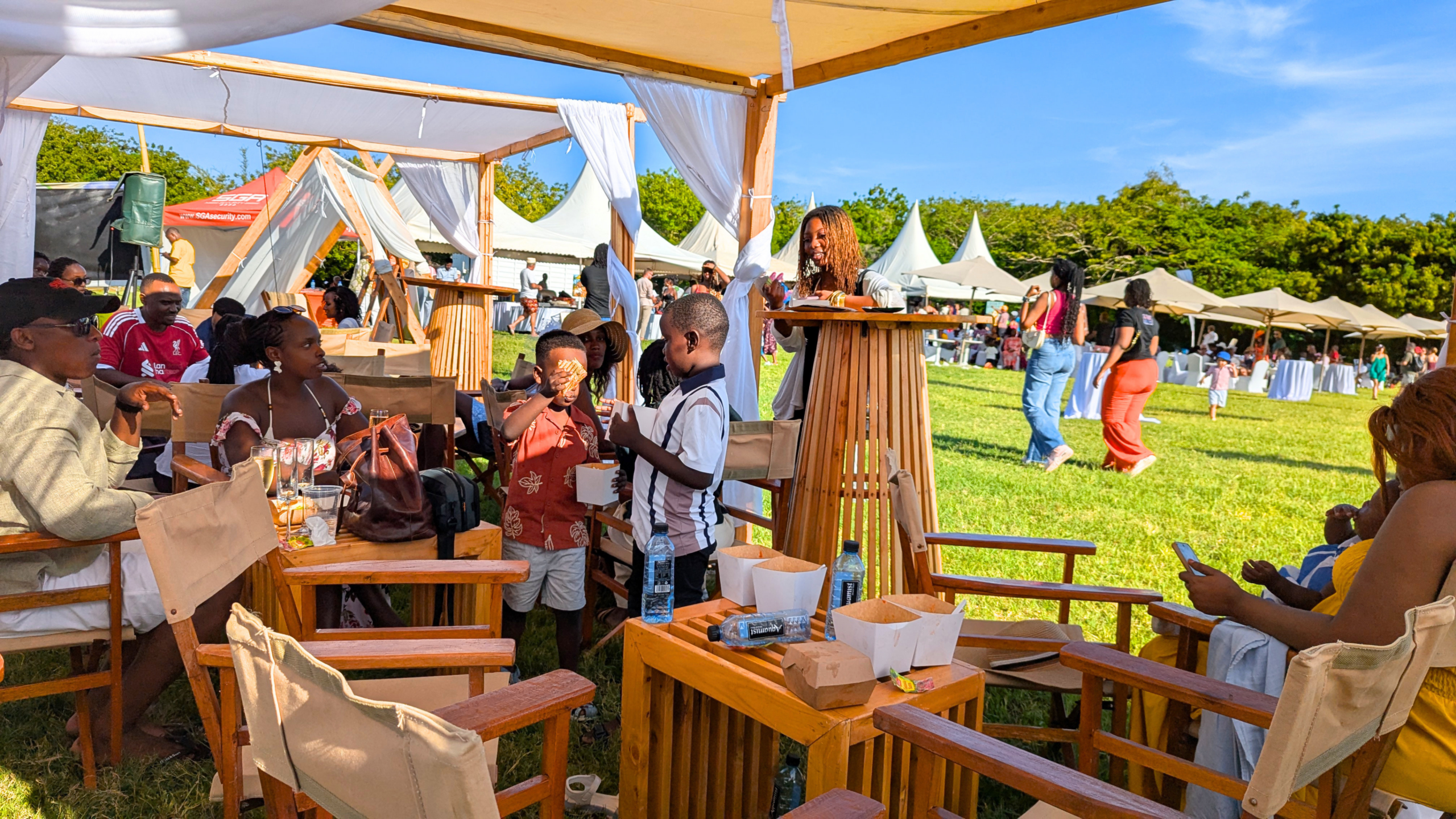 Goat Derby visitors gathering around wooden tables and chairs