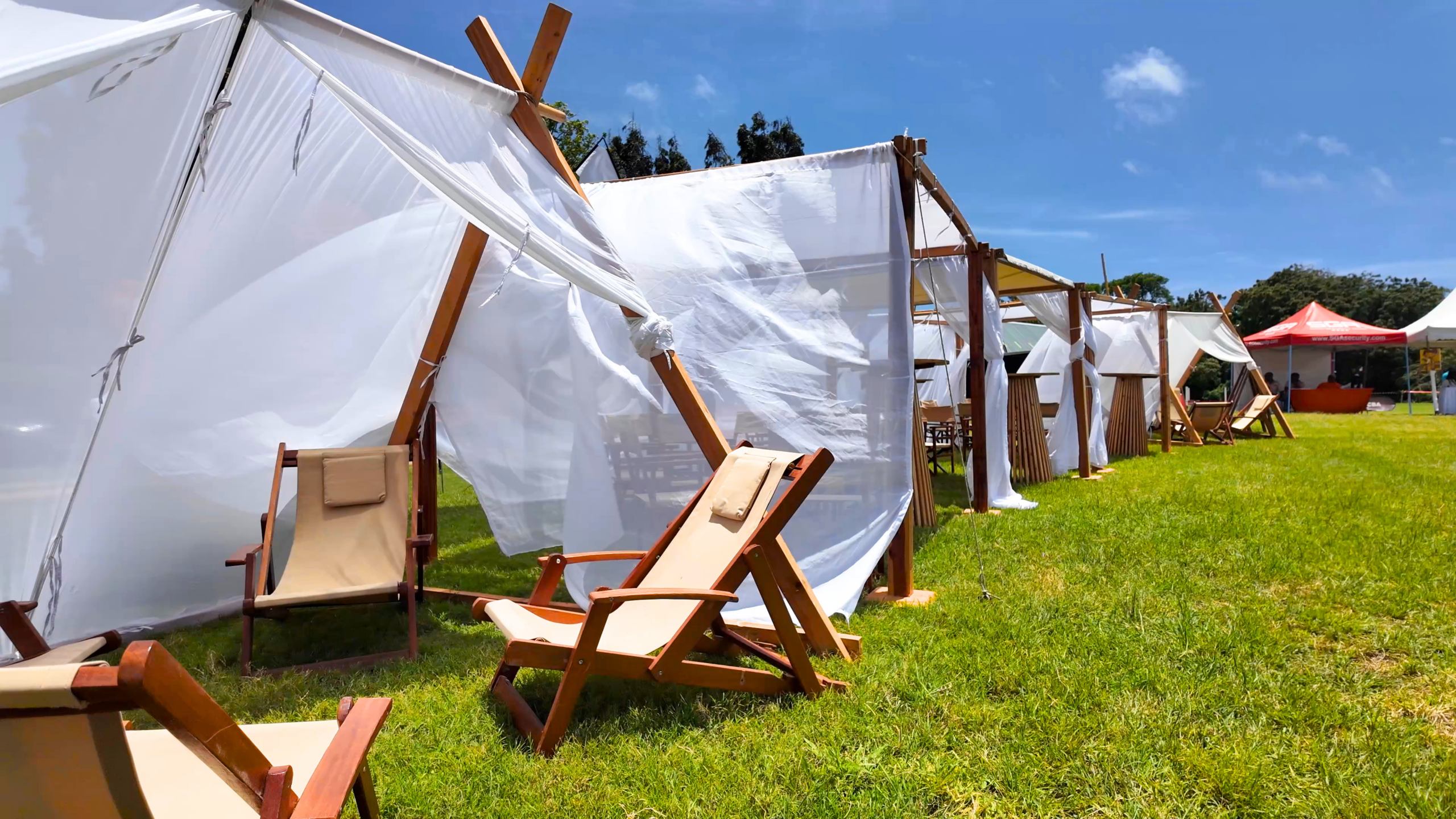 White fabric canopies and reusable wooden furniture on the Goat Derby lawn
